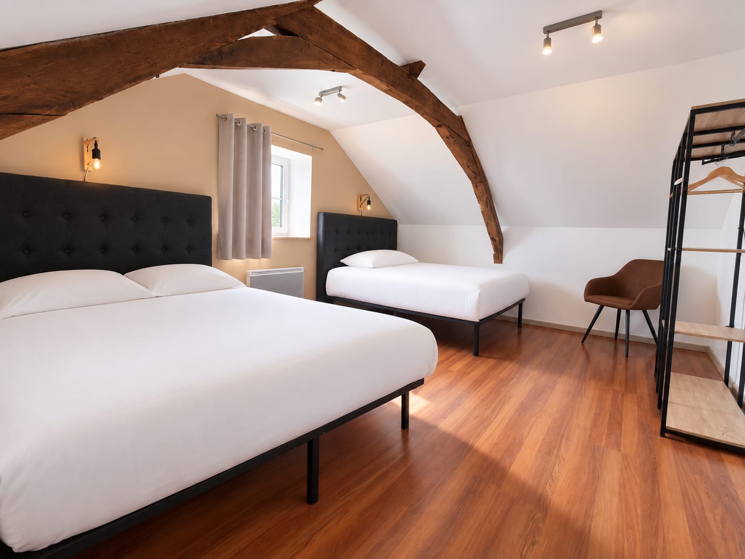 Chambre familiale sous charpente avec lit double et lit simple